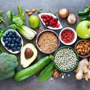 Healthy food selection with fruits, vegetables, seeds, superfood, cereals on gray background